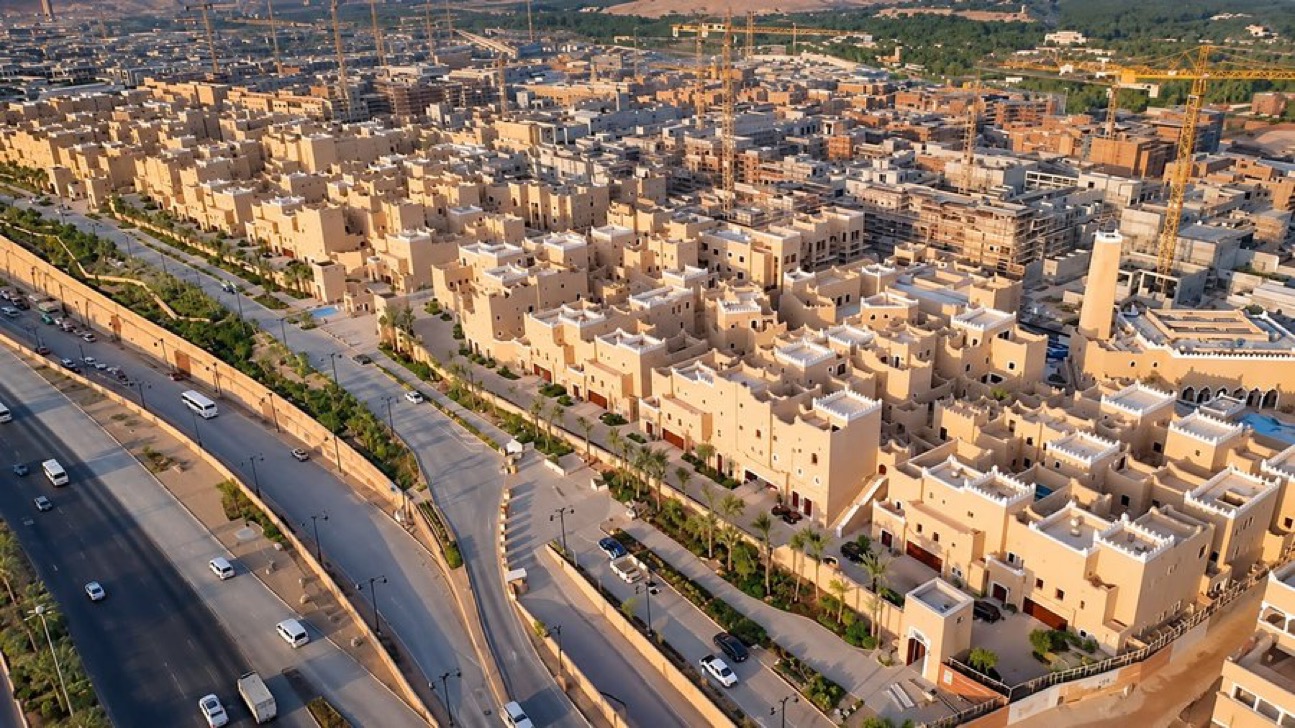 Aerial view of Najdi-style villas in Diriyah beside a landscaped road